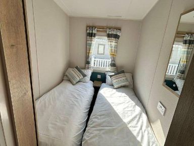 a bedroom with two single beds and curtains at Butlins Minehead - Holiday Accommodation 826 in Minehead