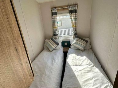 a bedroom with two single beds and striped curtains at Butlins Minehead - Holiday Accommodation 826 in Minehead