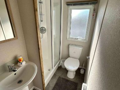 a bathroom with a shower, toilet, sink, and mirror at Butlins Minehead - Holiday Accommodation 826 Minehead