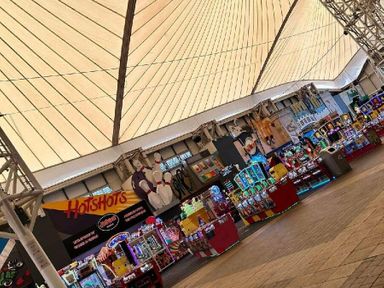 an indoor arcade featuring various game machines and colorful decorations at Butlins Minehead - Holiday Accommodation 826, Minehead
