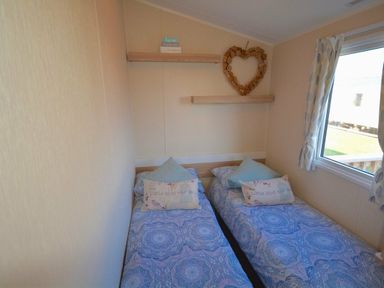 a bedroom with two single beds beside a window at Perran Sands - Holiday Accommodation 8302, Perranporth