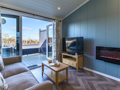 A living room with a television and sliding door at Coniston in Penrith