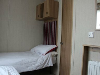 a bedroom with two single beds and wardrobe at White Acres Holiday Park - Holiday Accommodation 895 in Newquay