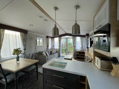 a living room with a sofa and dining area at Perran Sands - Holiday Accommodation 8982 in Perranporth