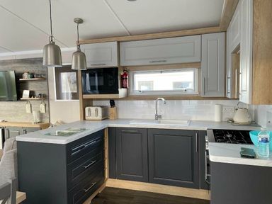 a kitchen with a sink, countertop, cabinets, and appliances at Perran Sands - Holiday Accommodation 8982, Perranporth