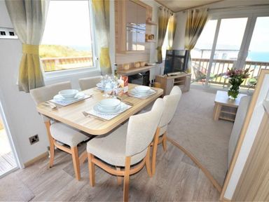 a dining area with a table set for four at Perran Sands - Holiday Accommodation 9657 in Perranporth
