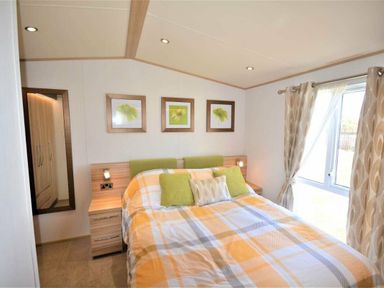 a bedroom with a bed and framed art at Perran Sands - Holiday Accommodation 9657 Perranporth