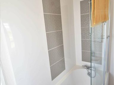 a bathroom with a shower and decorative tiles at Perran Sands - Holiday Accommodation 9657, Perranporth