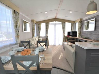 a living room with a dining table set for breakfast at Perran Sands - Holiday Accommodation 9871 Perranporth