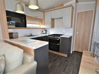 a kitchen with cabinets, an oven, and a countertop at Perran Sands - Holiday Accommodation 9871 in Perranporth