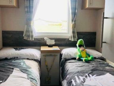 a bedroom with two single beds and a window at Perran Sands - Holiday Accommodation 9871, Perranporth