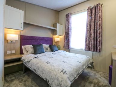 A bedroom with a double bed and two bedside lamps at Blue Skies in Caernarfon