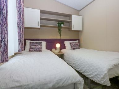 A bedroom with twin beds and a lamp at Blue Skies in Caernarfon