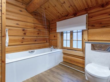 A bathroom with a bath tub and toilet at Kinder Lodge (Pet) Fowlis near Dundee