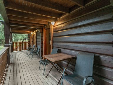 An outdoor deck with chairs and a table at Kinder Lodge (Pet) Fowlis near Dundee