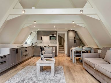 A living room and kitchen with a sofa and dining area at St Ives Studio Praze-An-Beeble