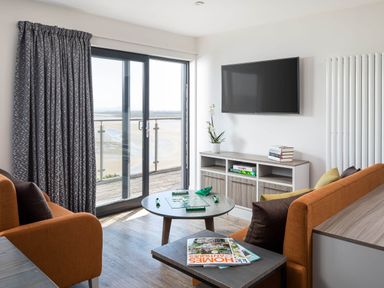 A living room with a television and coffee table at Ferry Hills in Laugharne