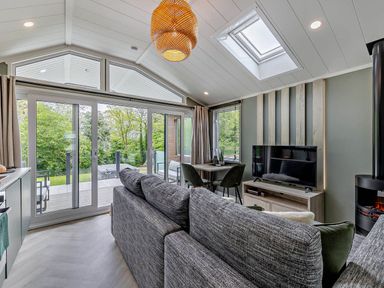 A living room with a sofa and dining area at Prion Spa, Llandyrnog
