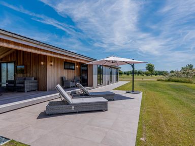 A patio with lounge chairs and an umbrella at Darwin Retreat in Wigton