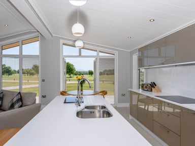 A kitchen with a sink and countertop overlooking the garden at Darwin Retreat in Wigton