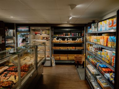 An interior view of a grocery store showing shelves with packaged food and drinks at The Sheraton Retreat in Aspatria