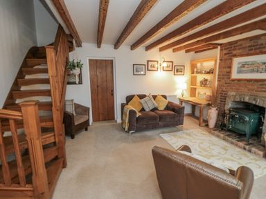 A living room with a sofa and a staircase at 21 High Street, Scarborough