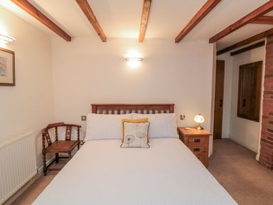 A bedroom with bed, side table, chair and lamp at 21 High Street in Scarborough