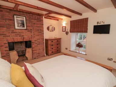 A bedroom with a fireplace and dresser at 21 High Street Scarborough