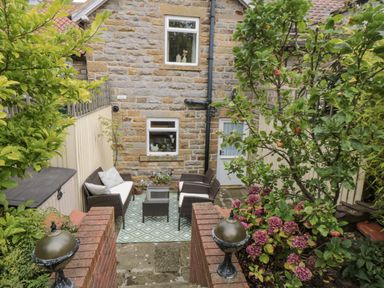A garden with seating area and plants at 21 High Street Scarborough