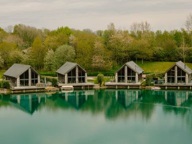 A view of cabins by a lake surrounded by trees at Wordsworth in Aspatria