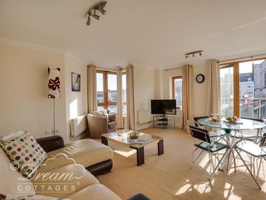A living room with a sofa and a table at Harbourside Apartment in Weymouth