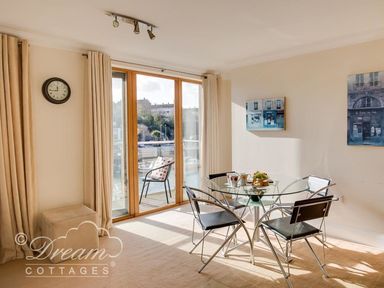 A dining room with a glass table and four chairs at Harbourside Apartment Weymouth