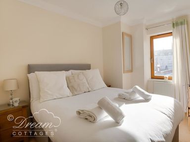 A bedroom with a double bed and a lamp at Harbourside Apartment in Weymouth