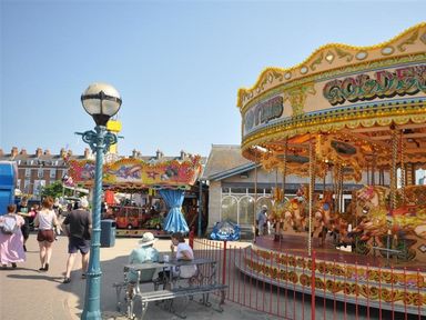 A carousel and people at a carnival area at Harbourside Apartment in Weymouth