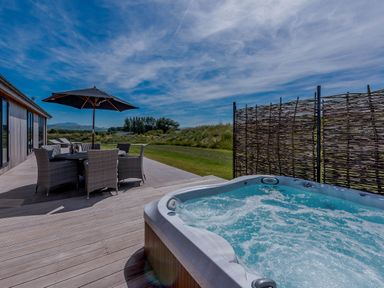 An outdoor area with a hot tub and dining table at Wellington in Wigton