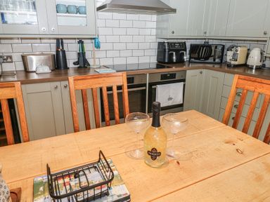 A kitchen with a dining table and kitchen appliances at 58A South Ford Road in Dartmouth