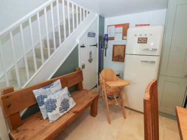 A kitchen with a staircase and a high chair at 58A South Ford Road in Dartmouth