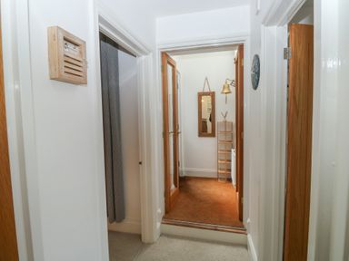 A hallway with a mirror and a shelf at 58A South Ford Road in Dartmouth