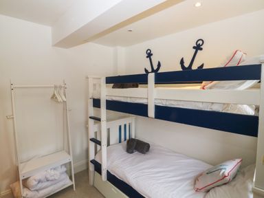 A bedroom with a bunk bed and a clothes rack at 58A South Ford Road in Dartmouth