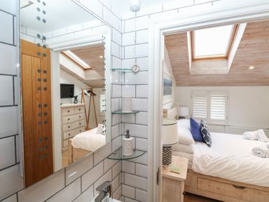 A bedroom with a mirror, dresser, and bed at 58A South Ford Road in Dartmouth