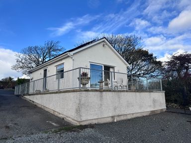 A house with a railing and plant pot at Ty Nain in Bodorgan