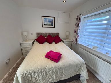 A bedroom with a bed and bedside tables at Ty Nain in Bodorgan