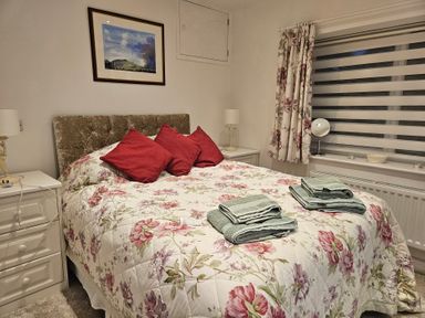 A bedroom with a bed and bedside tables at Ty Nain Bodorgan