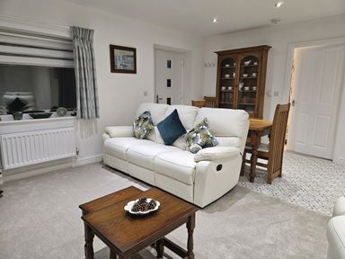 A living room with a sofa and table at Ty Nain in Bethel