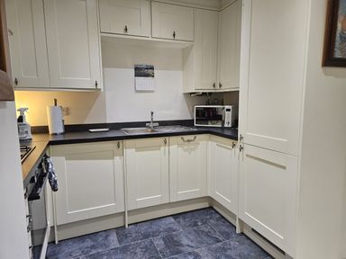 A kitchen with a sink and microwave at Ty Nain Bethel