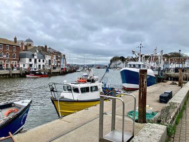 A harbor with boats and buildings at 12 Brewhouse Place Weymouth