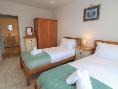 A bedroom with two beds and a nightstand at Brewery View in Weymouth