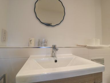 A sink with a mirror and toiletries at Brewery View in Weymouth