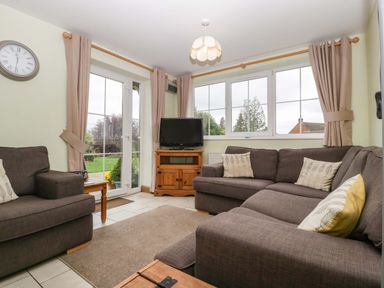 A living room with sofas and a television at Dovecote Cottage in Corse near Gloucester