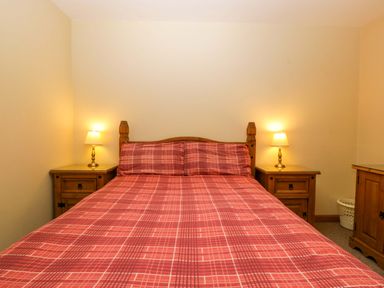 A bedroom with a bed and nightstands at Dovecote Cottage Corse near Gloucester